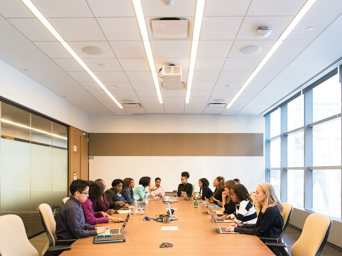 A full boardroom meeting around a long conference table